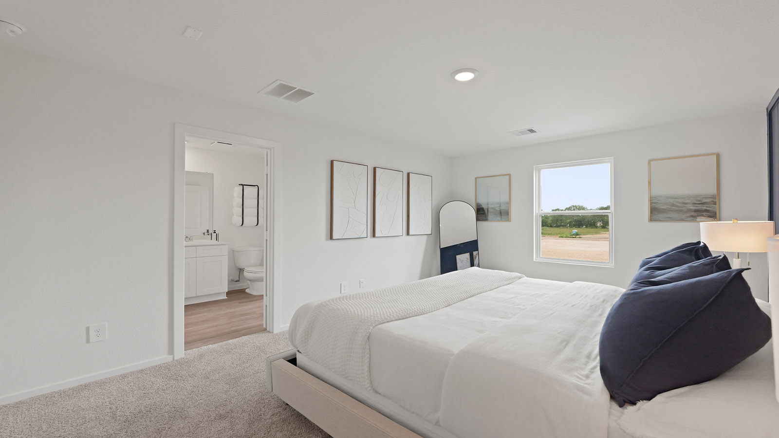 Primary bedroom with carpet flooring and bright windows.
