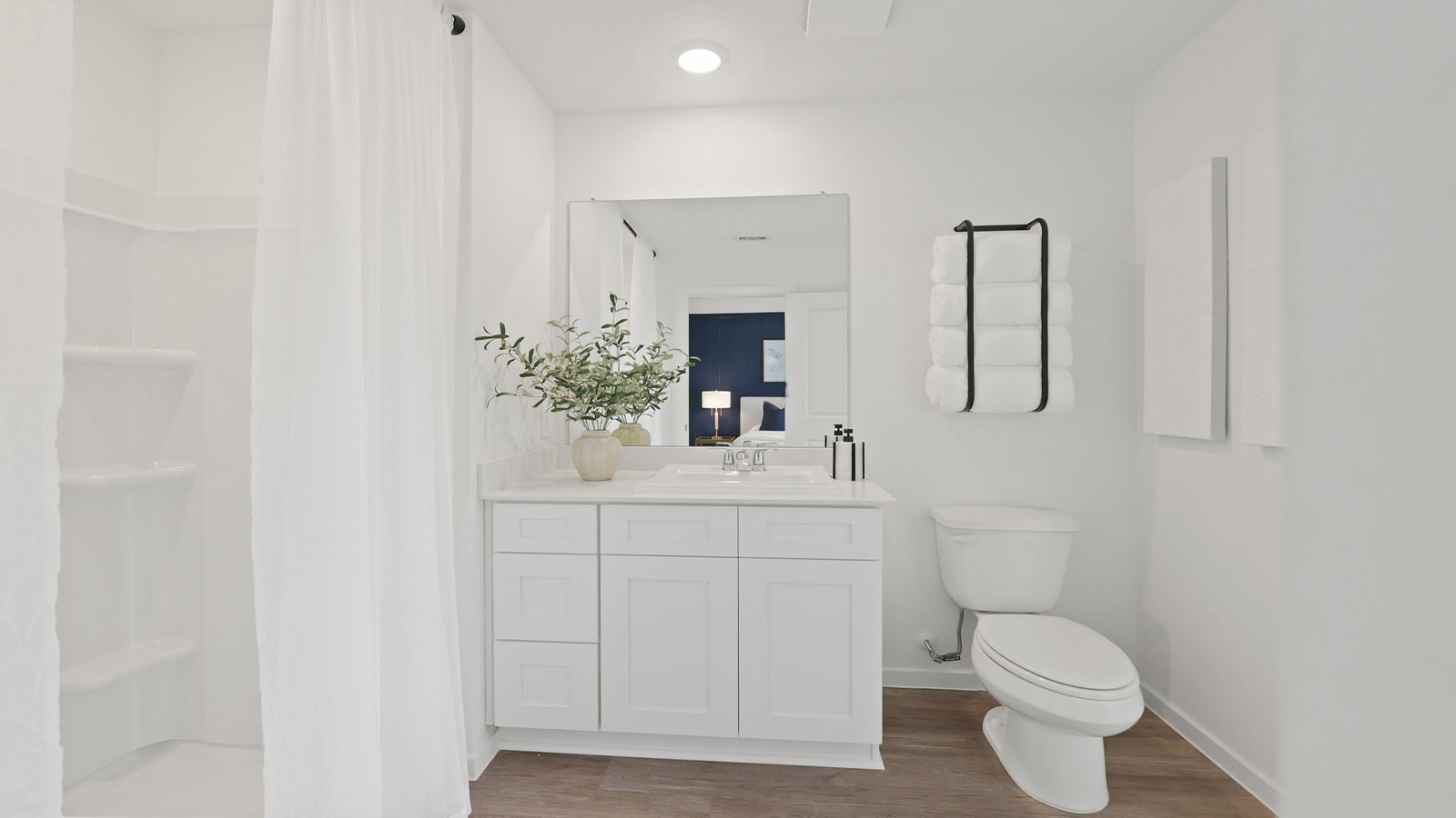Primary bathroom with a standing shower and vinyl flooring.