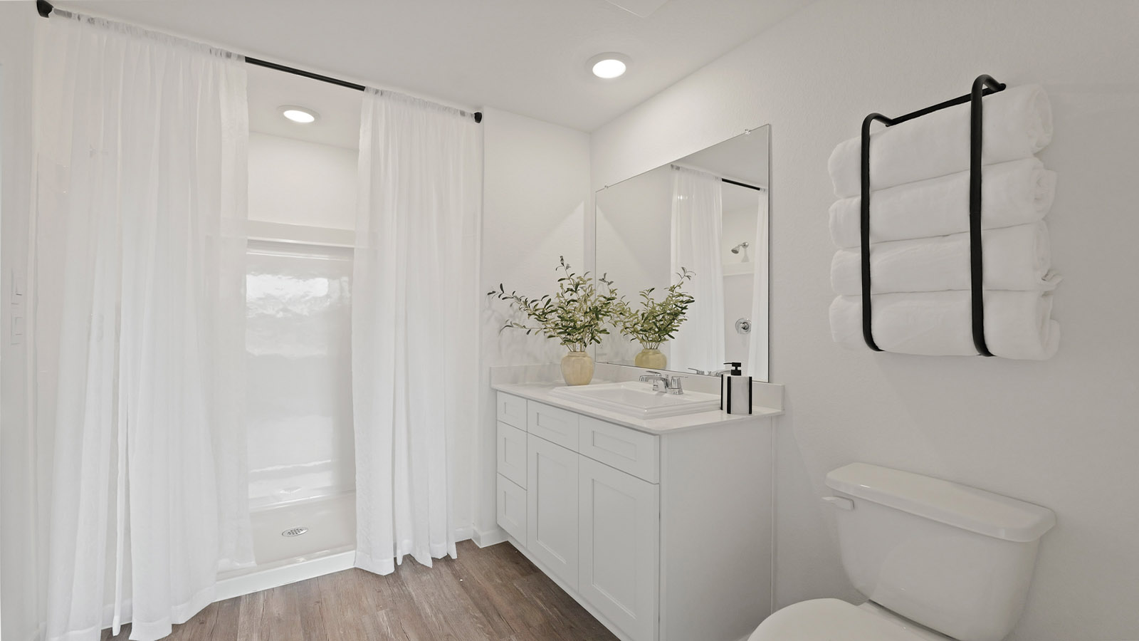 Primary bathroom with a standing shower and vinyl flooring.