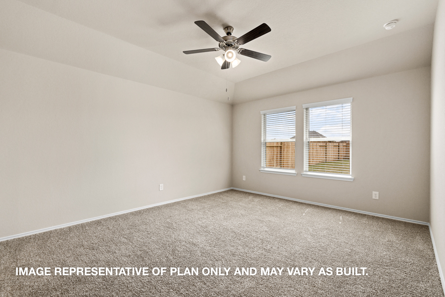 Primary bedroom with carpet flooring and two bright windows.