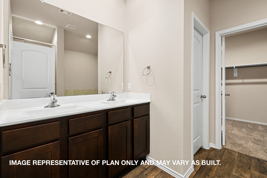 Primary bathroom with double sink and walk-in closet.