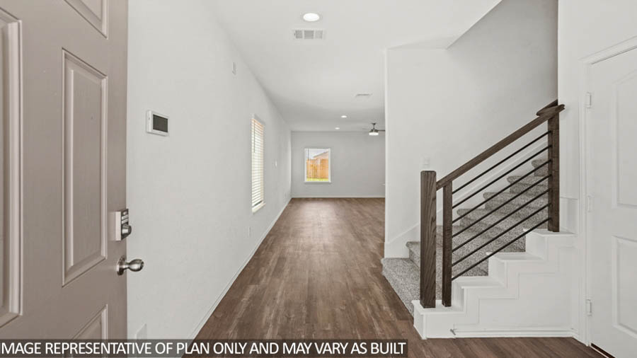 Entryway and foyer with vinyl flooring and a carpeted staircase.