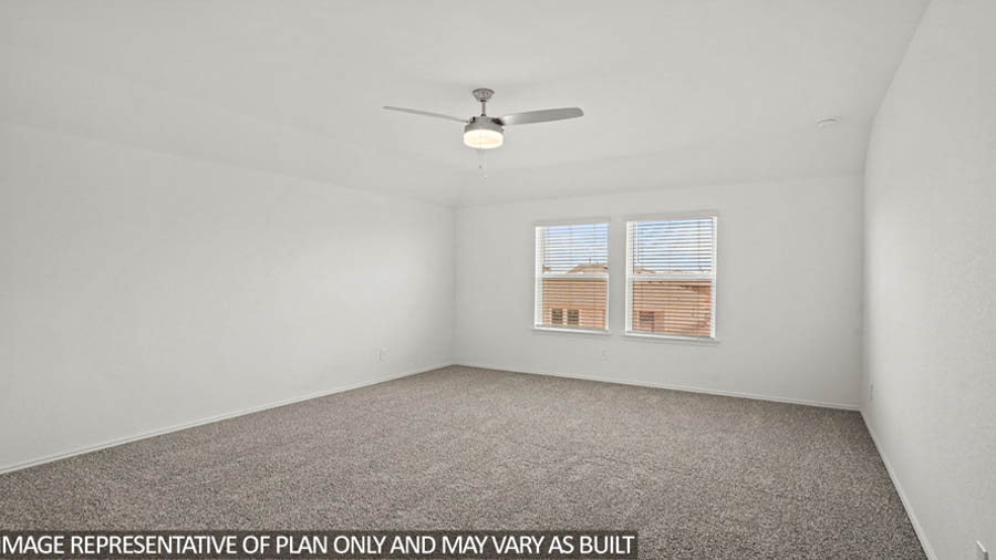 Primary bedroom with carpet flooring, bright windows, and a ceiling fan.