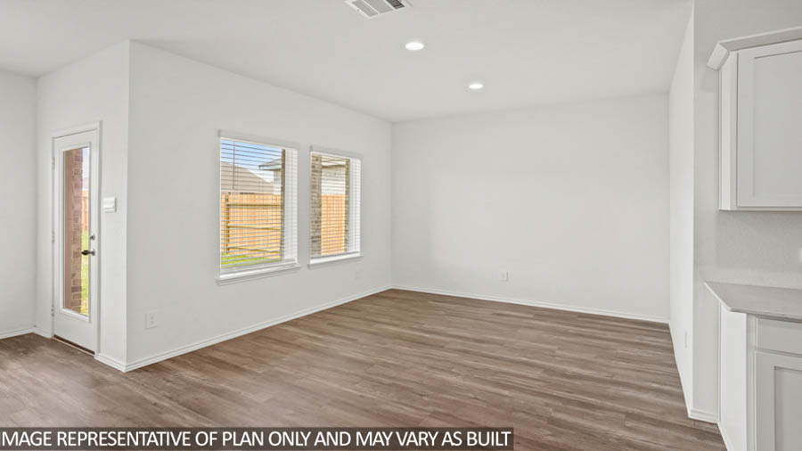 Dining area with vinyl flooring and bright windows.