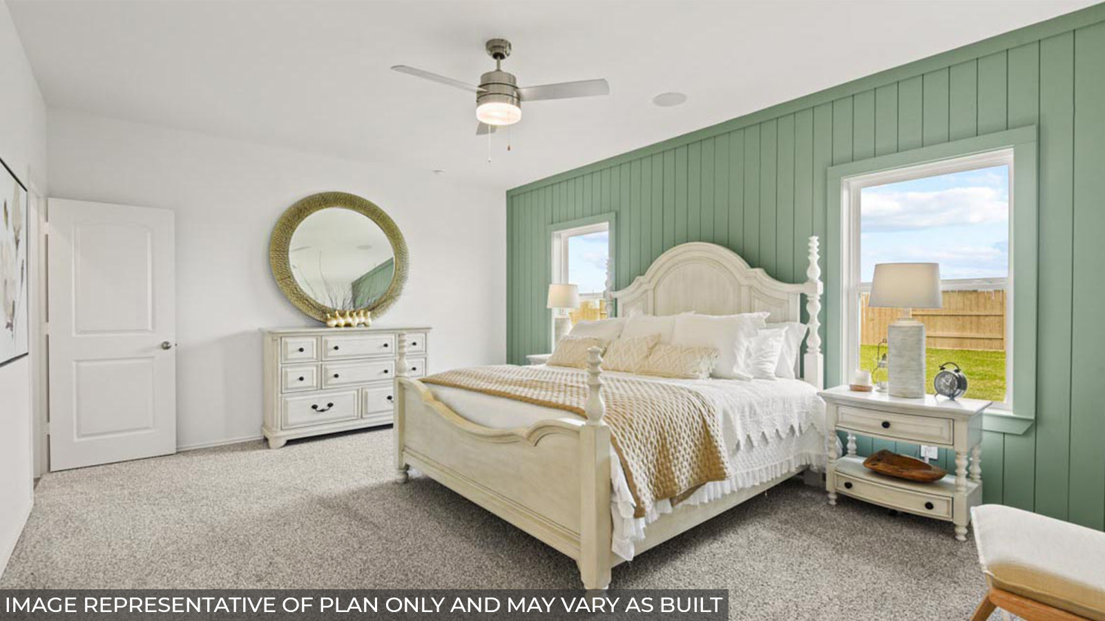 Primary bedroom with carpet flooring and bright windows.
