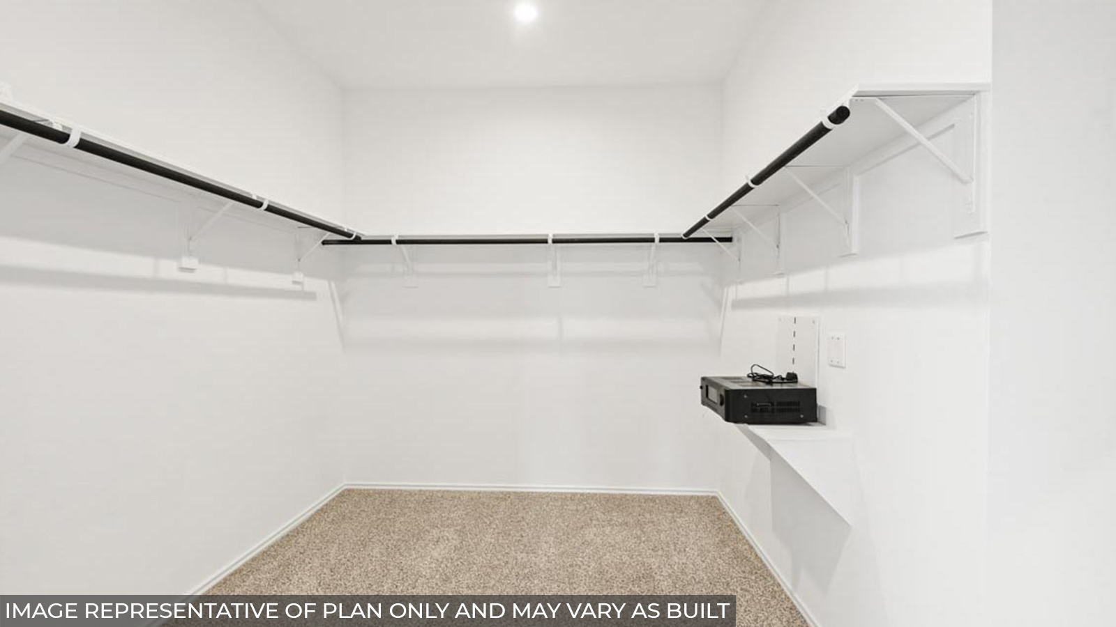 Spacious walk-in closet with carpet flooring and overhead storage space.