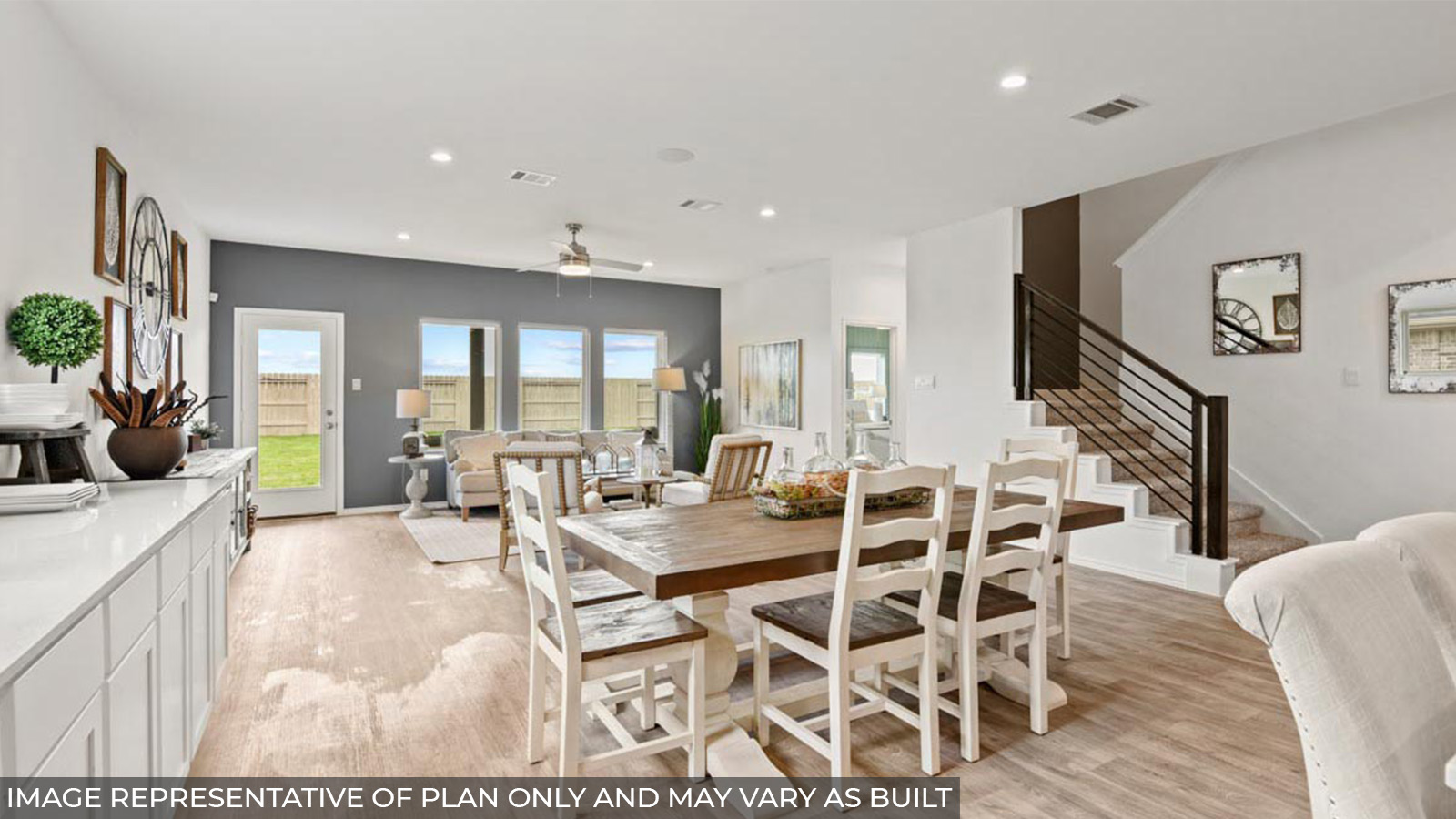 Open concept living and dining area with vinyl flooring and bright windows.