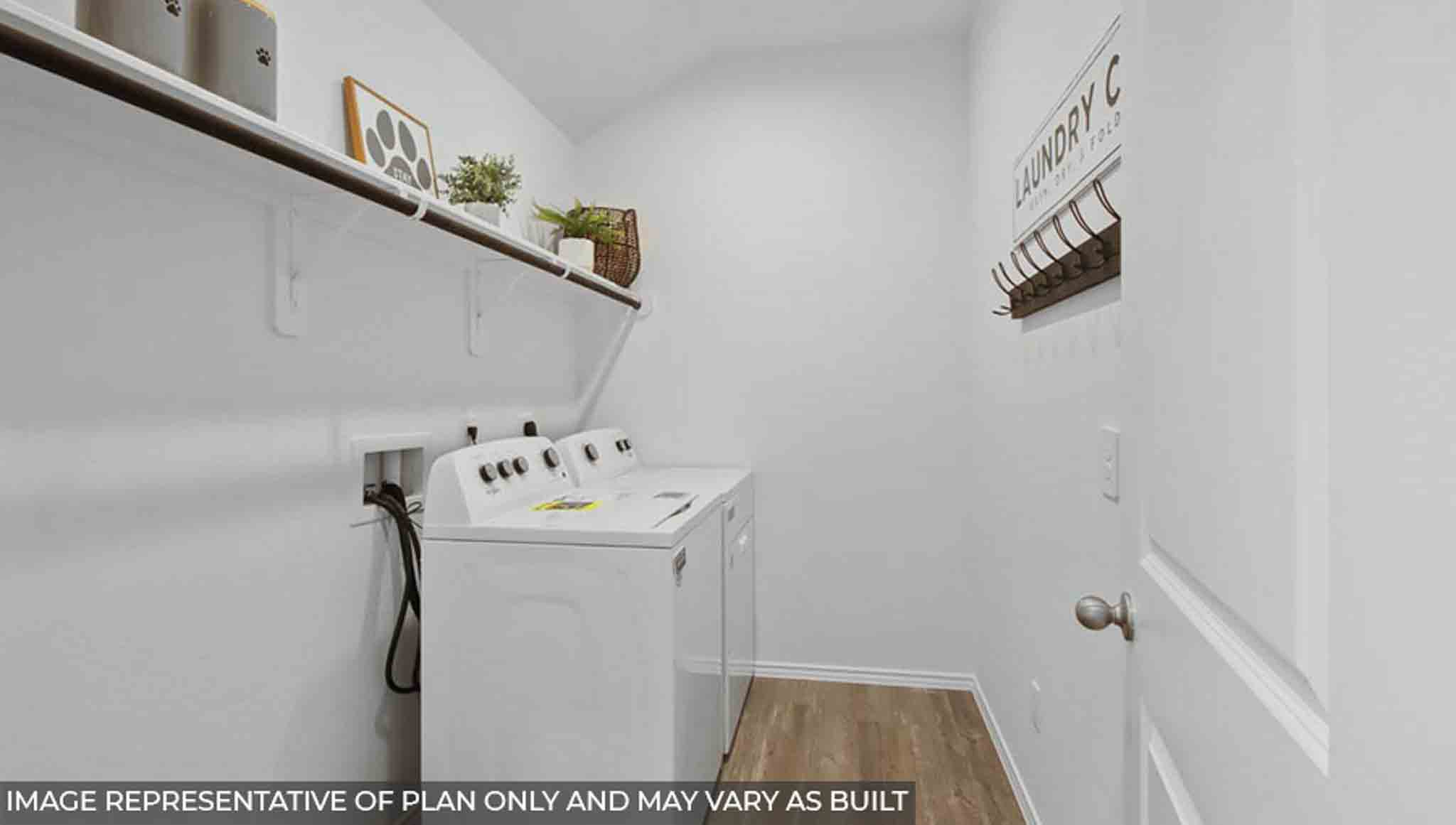 Utility room with vinyl flooring and overhead storage space.