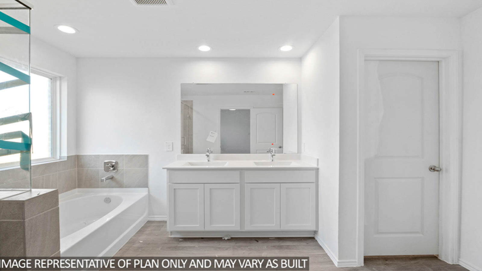Primary bathroom with a tile tub, a standing shower, and a double sink.