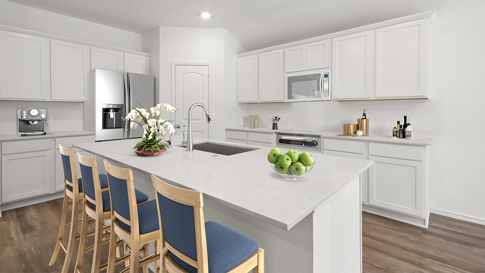 staged kitchen with an island, stainless-steel appliances, and a tall pantry