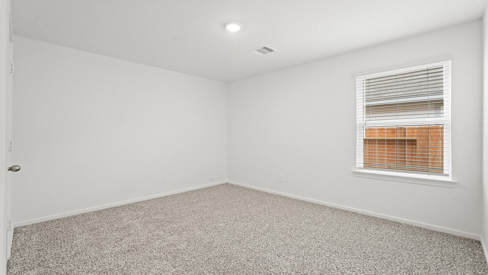 Secondary bedroom with carpet flooring