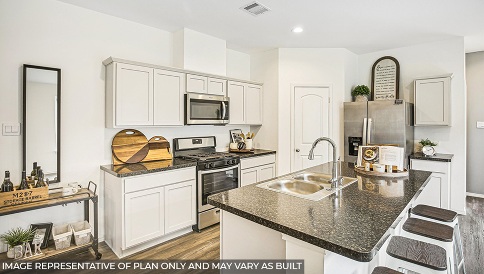 Kitchen with stainless-steel appliances, an island, and a tall pantry.