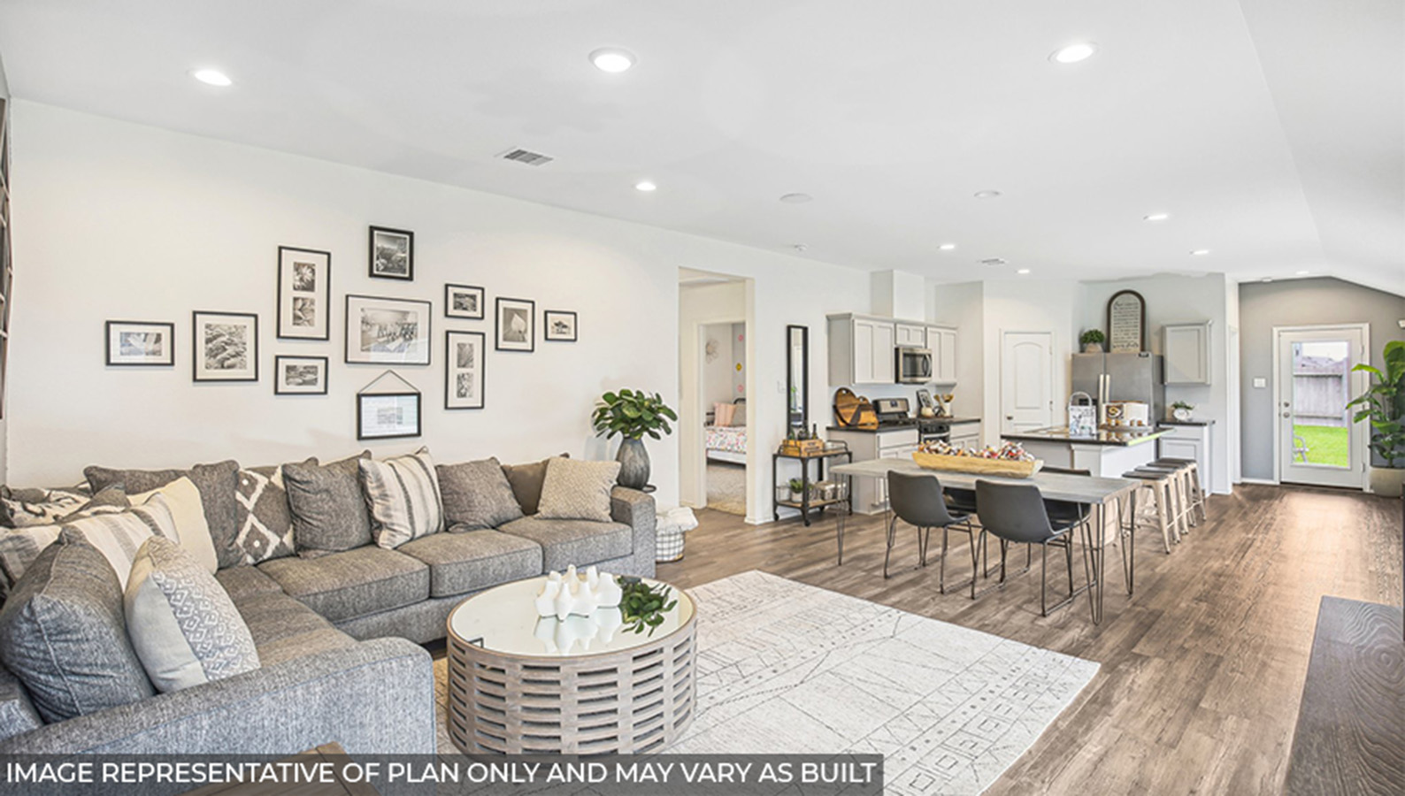 Open concept living and dining area with vinyl flooring and bright windows.