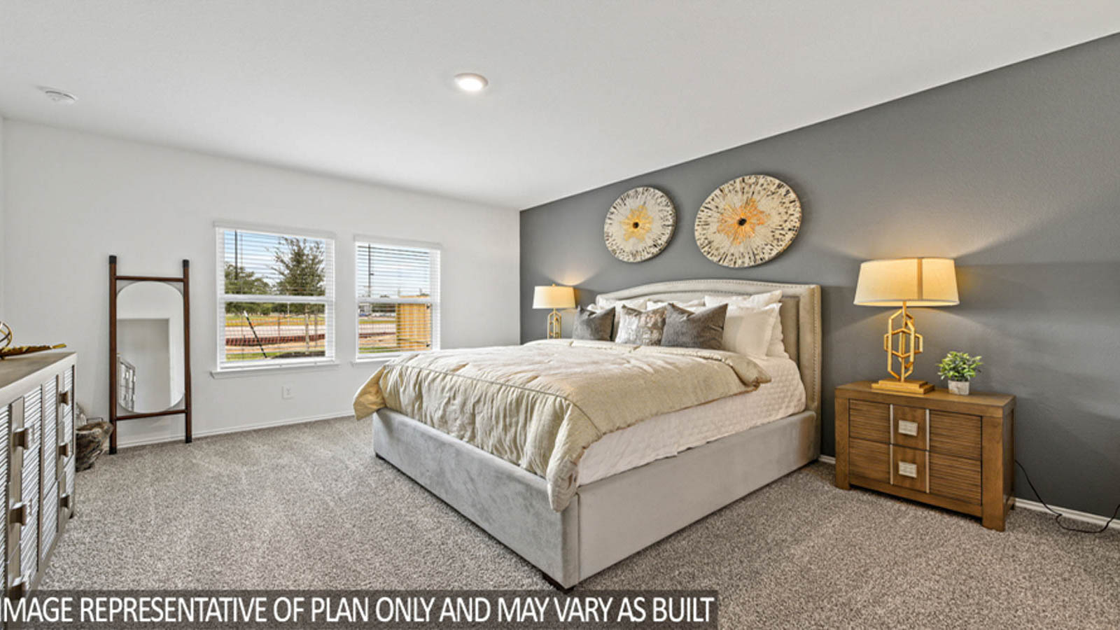 Primary bedroom with carpet flooring and bright windows.