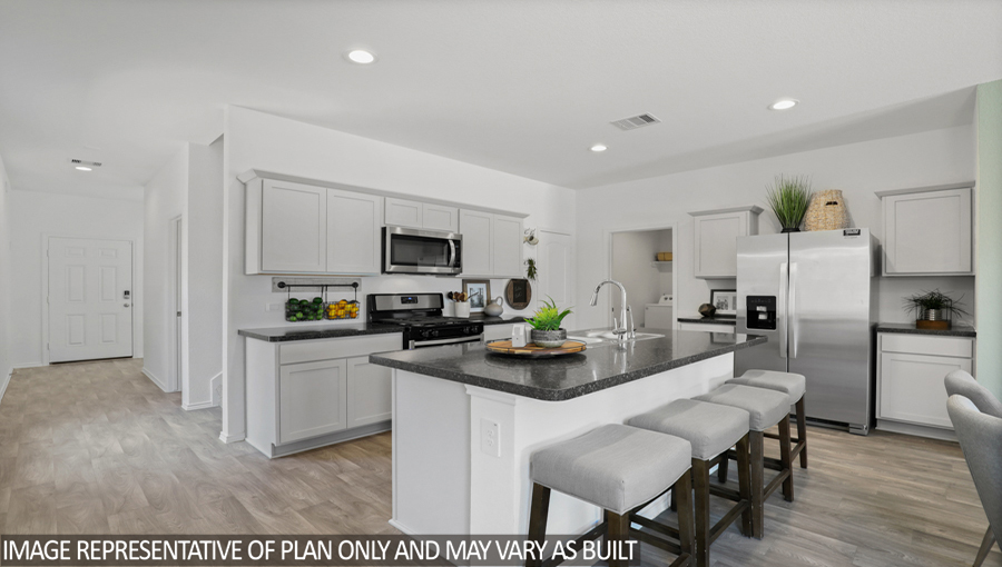 Kitchen with an island, stainless-steel appliances, and a bright window.