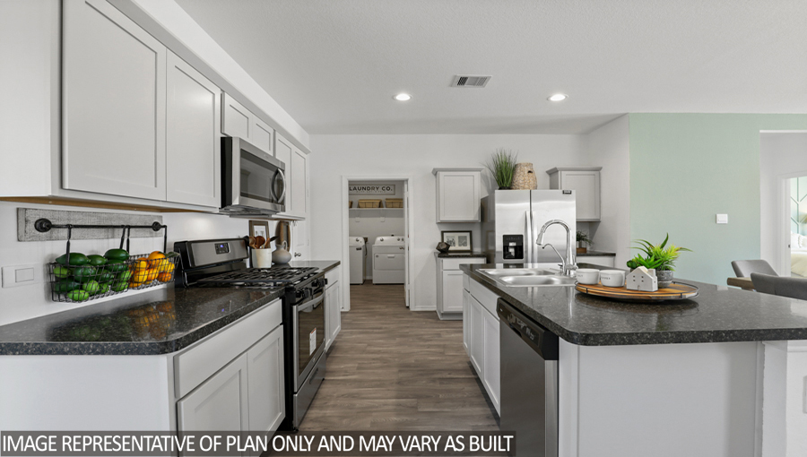 Kitchen with an island, stainless-steel appliances, and a bright window.