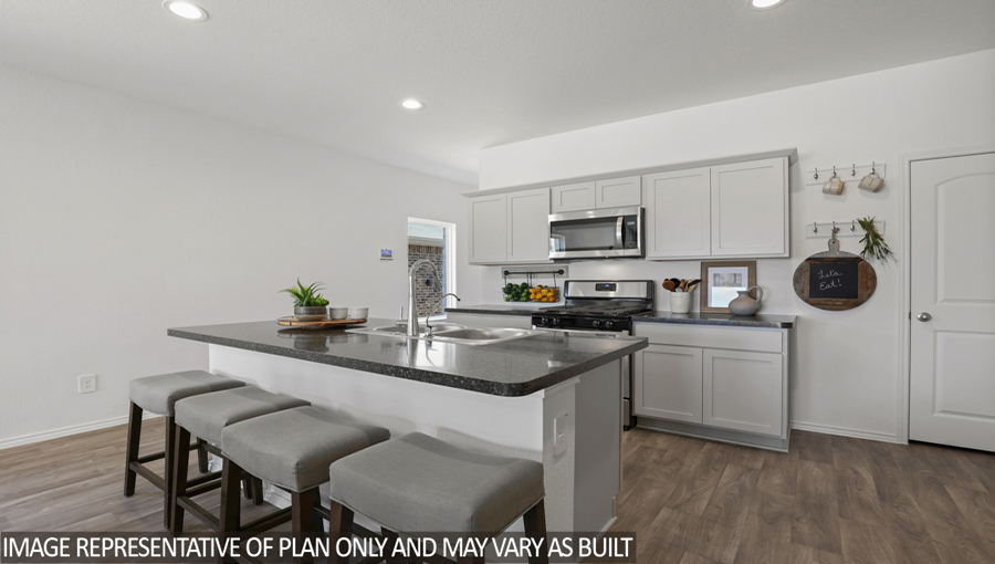Kitchen with an island, stainless-steel appliances, and a bright window.