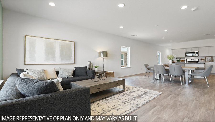 Open concept living and dining area with vinyl flooring and bright windows.