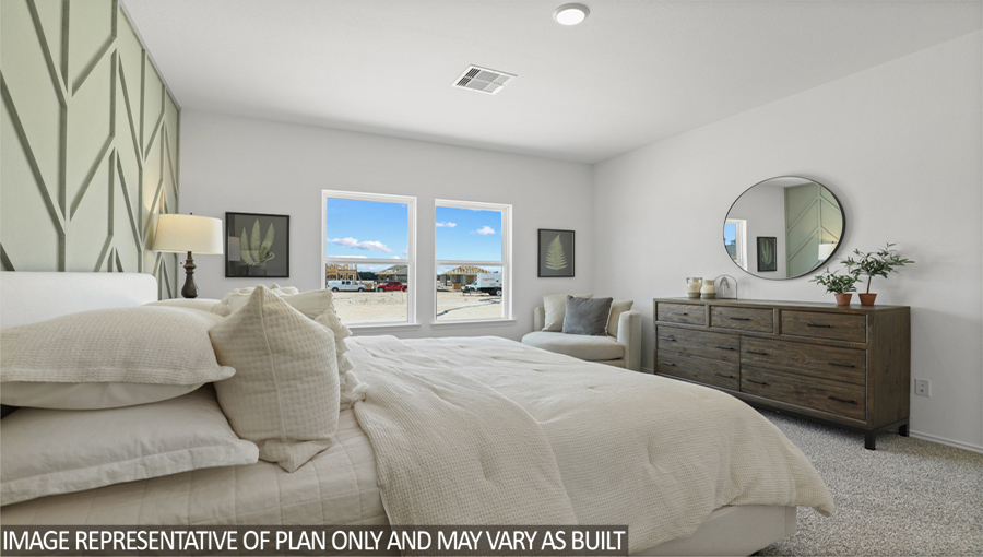 Primary bedroom with carpet flooring and bright windows.