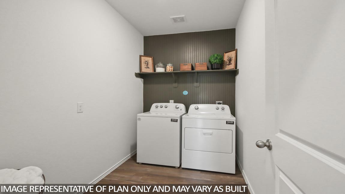 Utility room with vinyl flooring and overhead storage space.