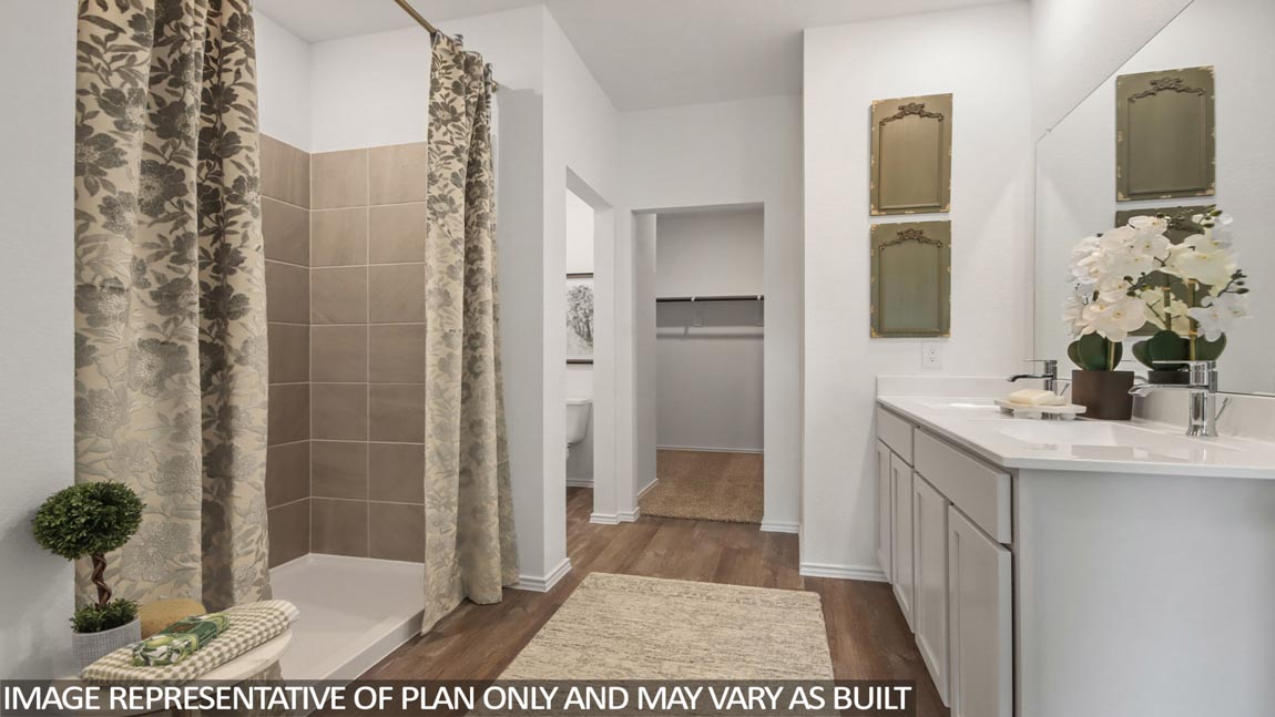 Primary bathroom with a standing shower, a double sink, a separate toilet room, and a spacious walk-in closet.