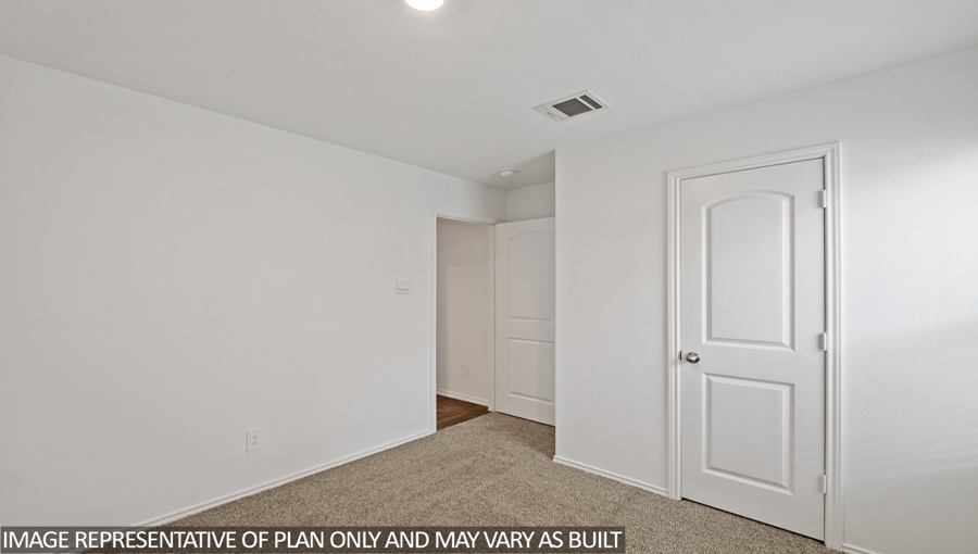 Secondary bedroom with carpet flooring.