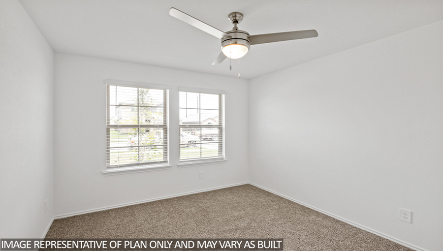 Secondary bedroom with carpet flooring and bright windows.