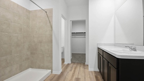 Primary bathroom with double sinks and tile standing shower