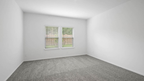 Primary bedroom with large windows and carpet
