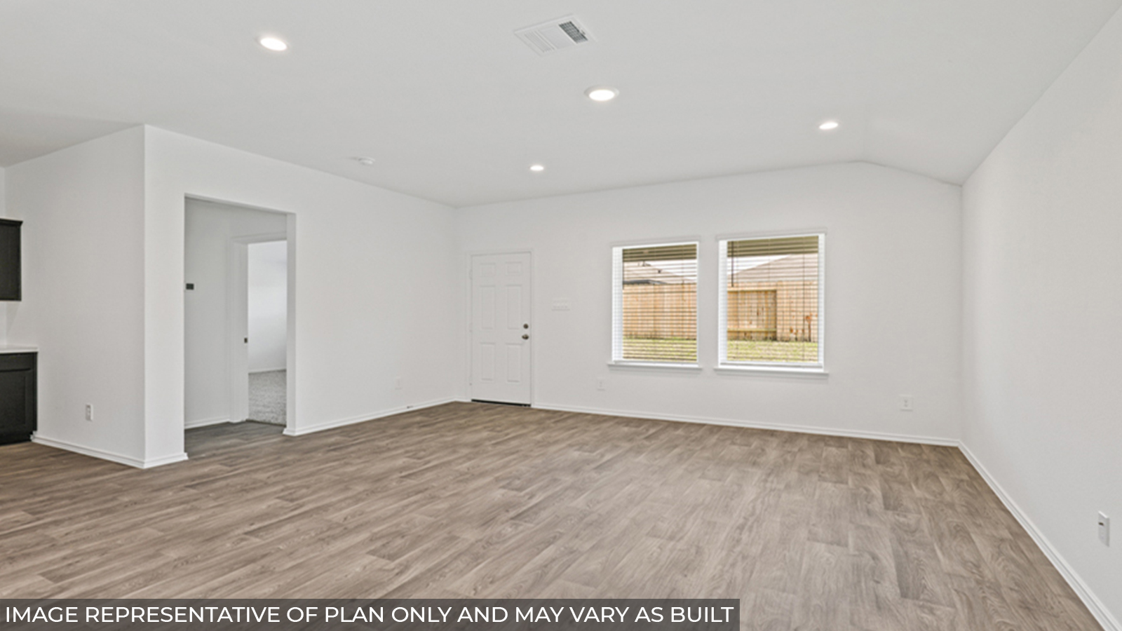 Open concept living and dining space with vinyl flooring and bright windows.