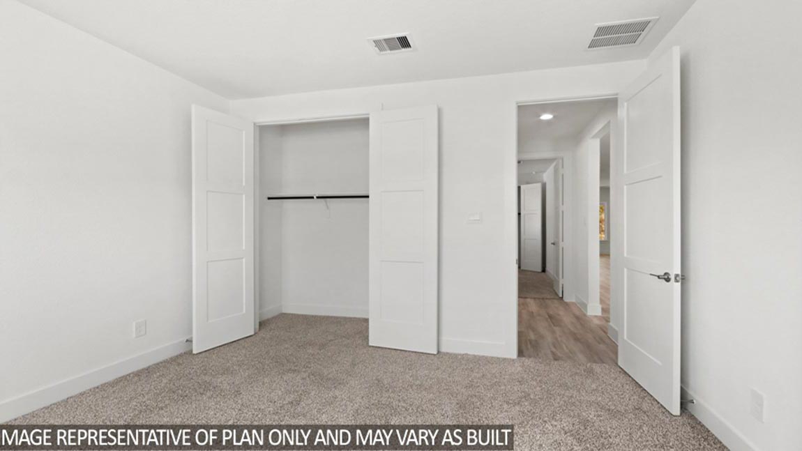 Secondary bedroom with carpet flooring and bright windows.