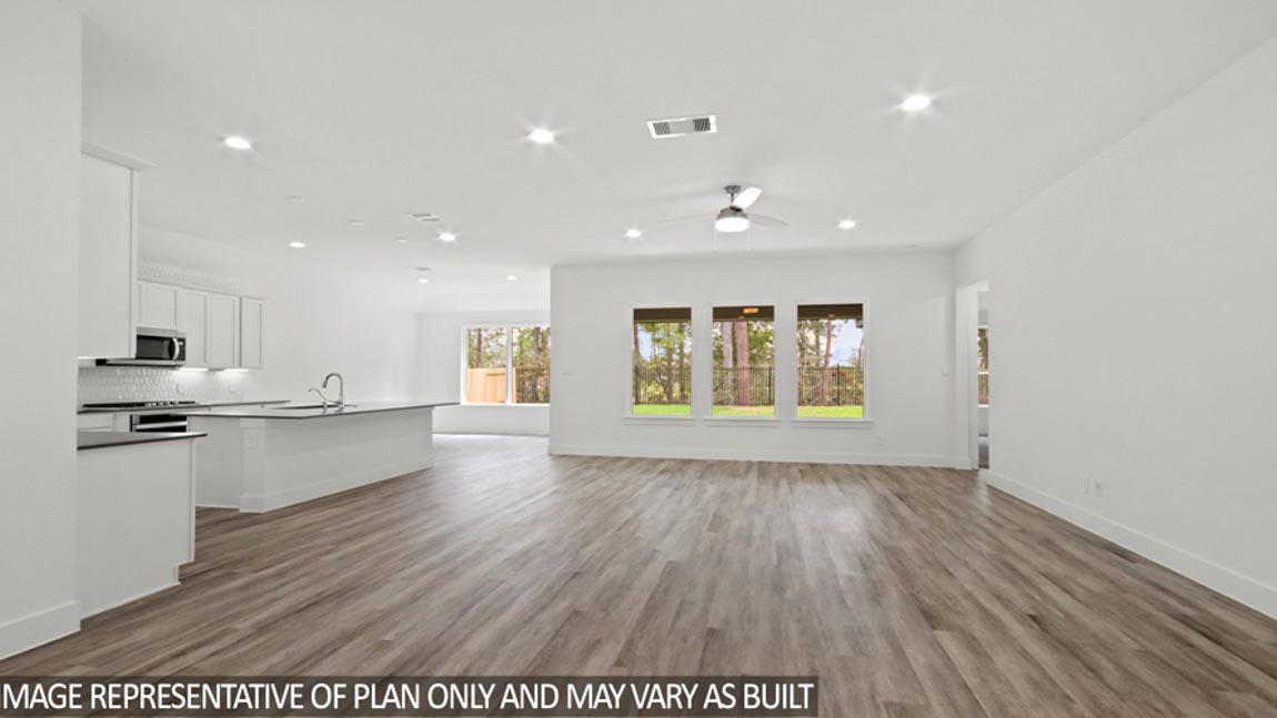 Open concept living and dining area with vinyl flooring and bright windows.