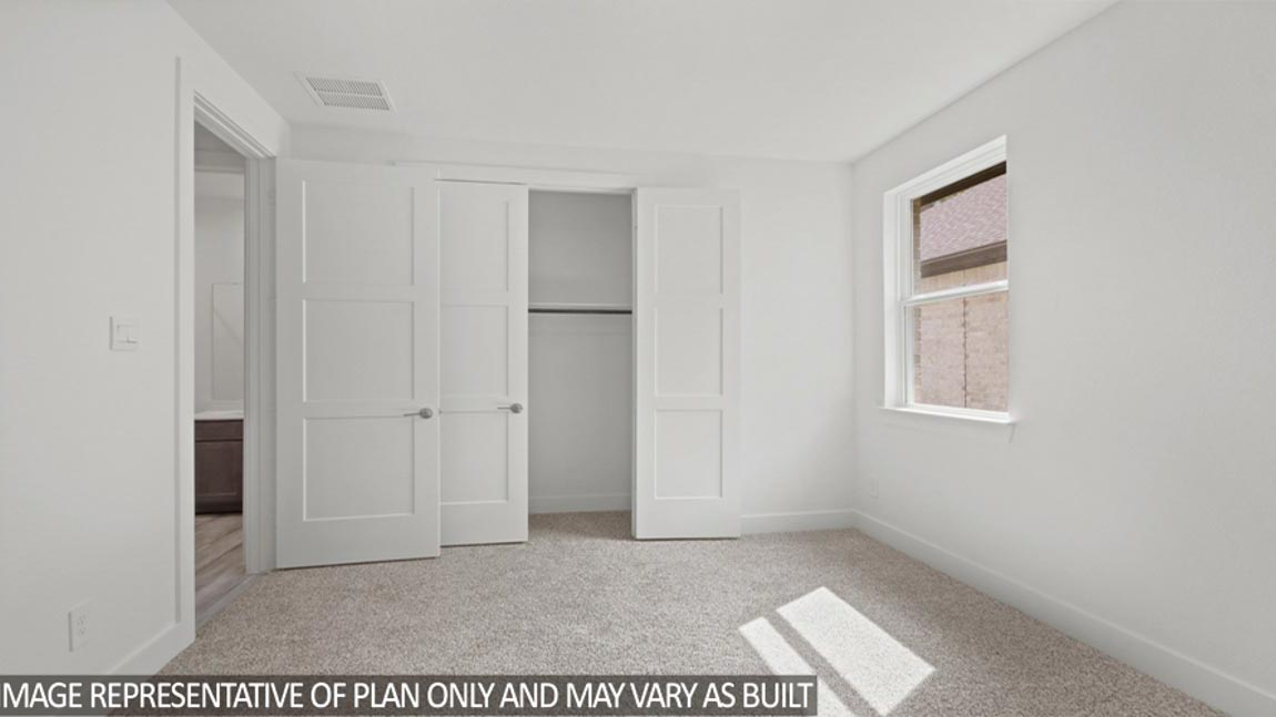Secondary bedroom with carpet flooring, a tall closet, a bright window, and an attached secondary bathroom.
