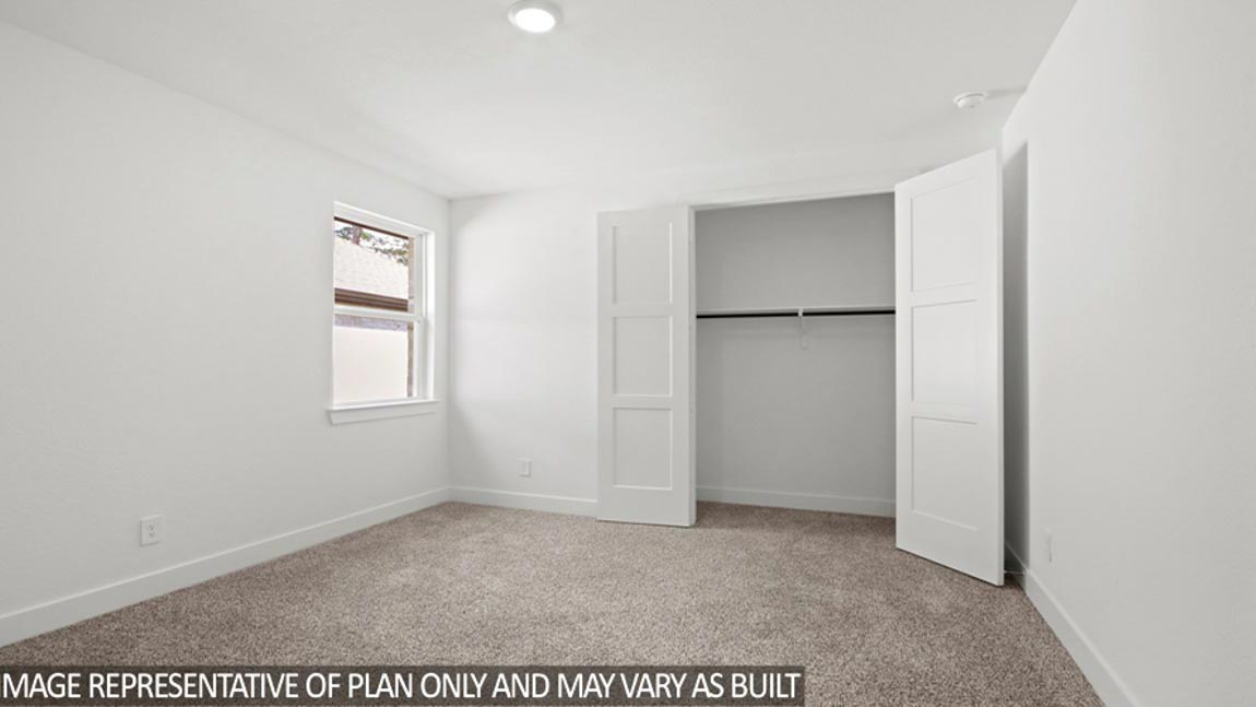 Secondary bedroom with carpet flooring and a bright window.