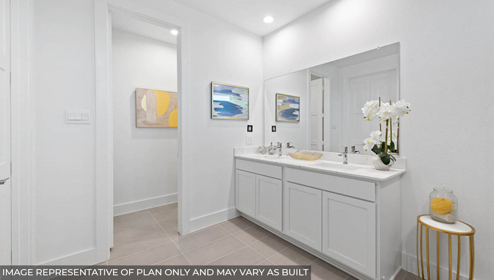 Staged primary bathroom with a double sink and a separate toilet room.