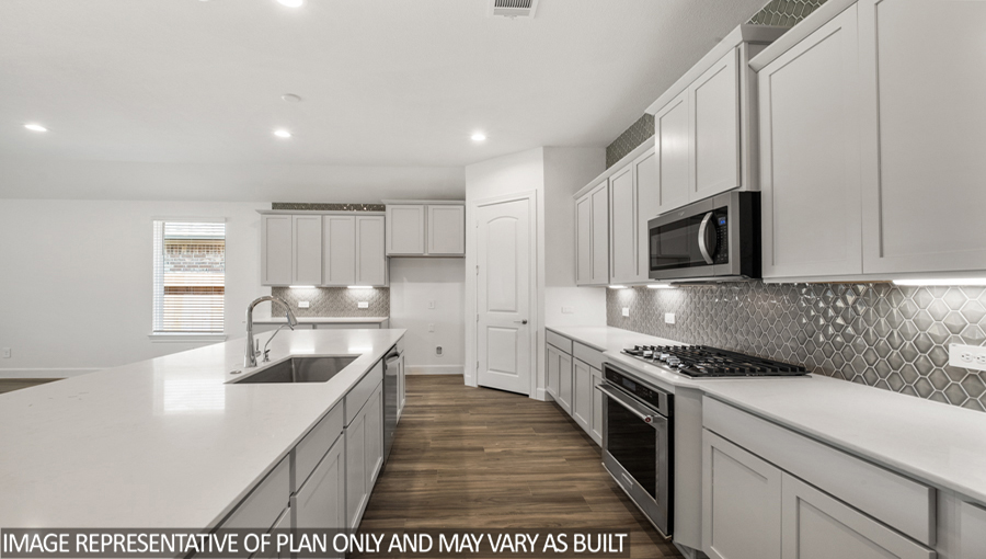 Kitchen with an island, tall pantry, and stainless-steel appliances.