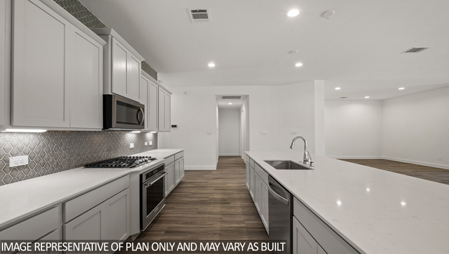 Kitchen with an island, tall pantry, and stainless-steel appliances.