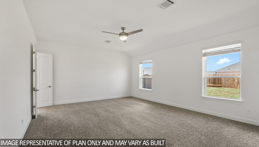 Primary bedroom with carpet flooring and bright windows.