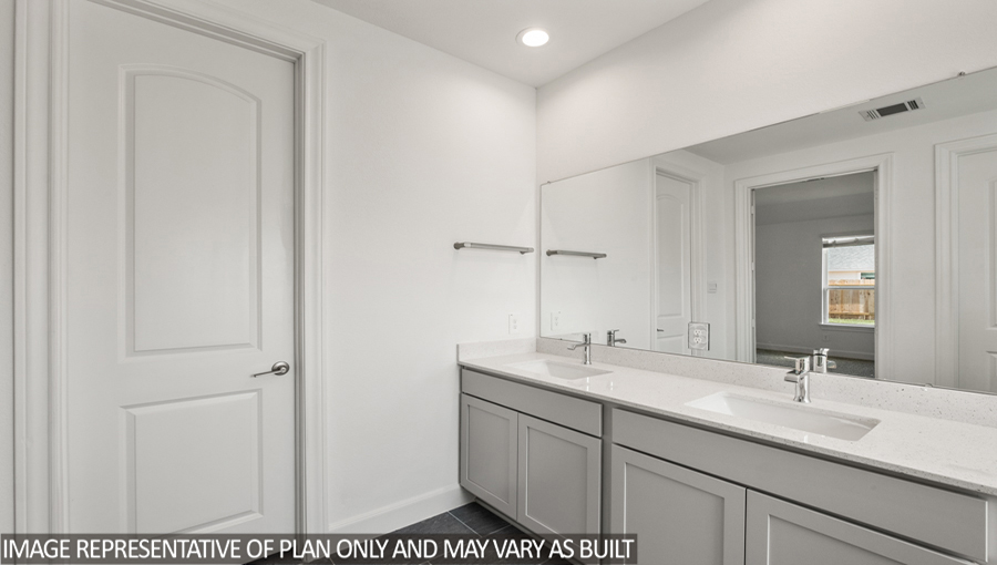 Primary bathroom with a double sink and a walk-in closet.