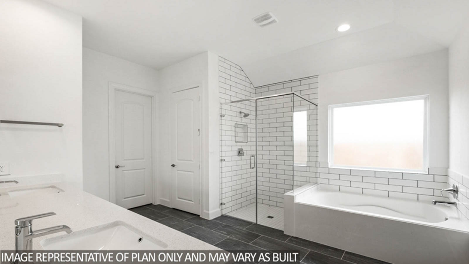 Primary bathroom with a tile tub, a frosted widow, and a standing shower with a glass door.