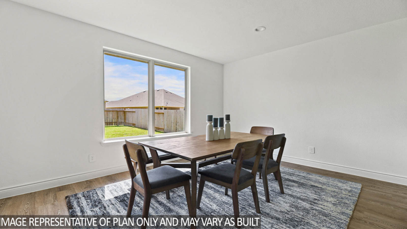 Dining area with vinyl flooring and bright windows.