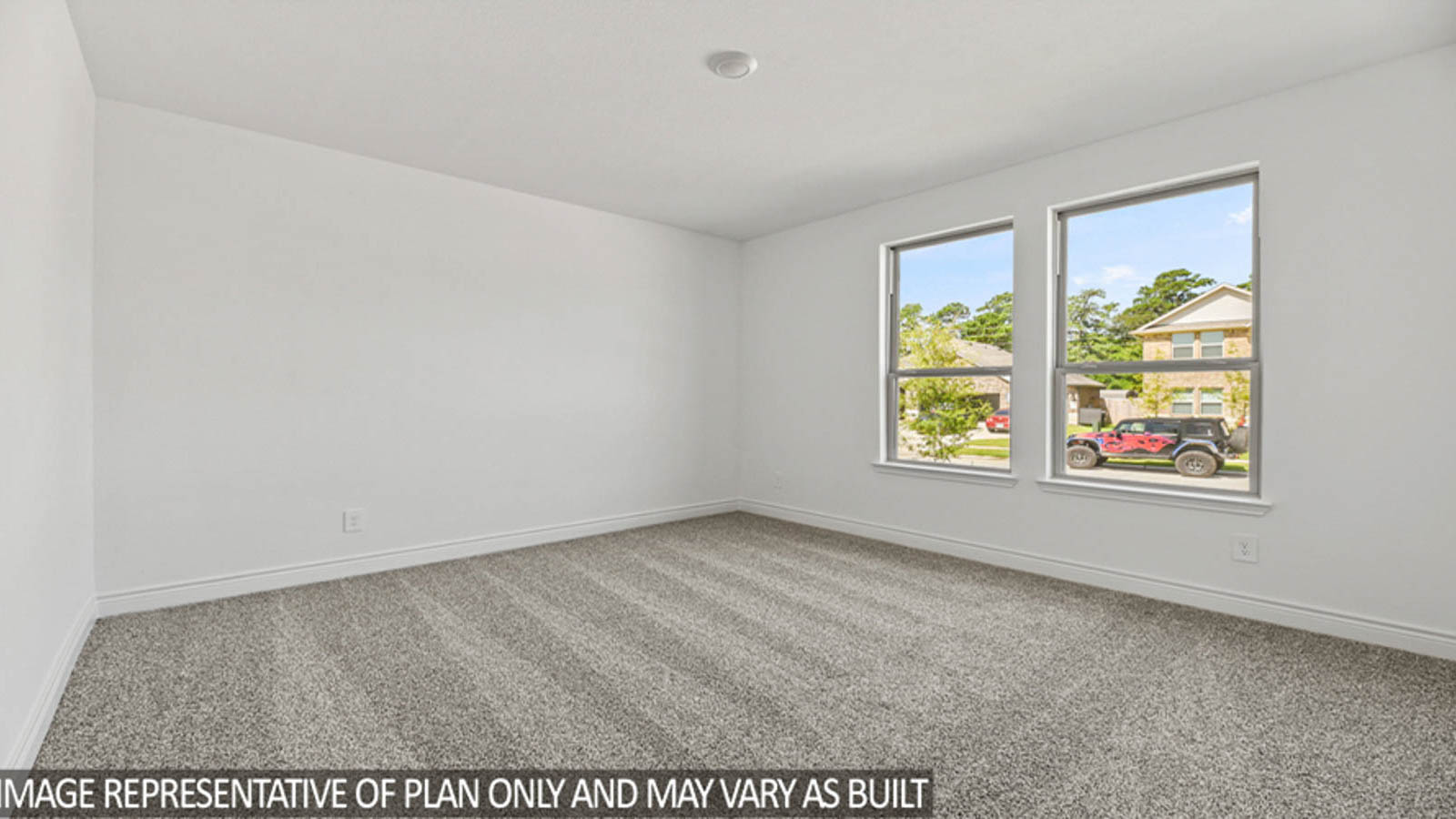 Secondary bedroom with carpet flooring and bright windows.