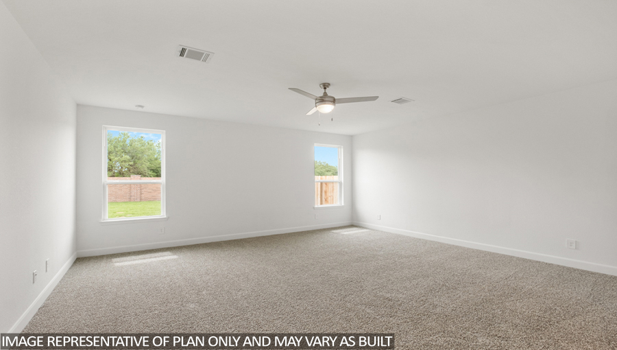 Primary bedroom with carpet flooring and bright windows.