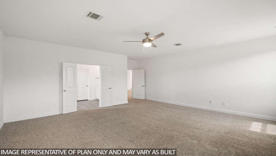 Primary bedroom with carpet flooring and a ceiling fan.