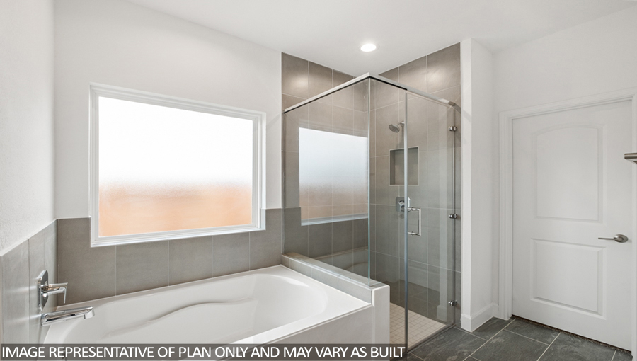 Primary bathroom with a tile tub, a standing shower with a glass door, and a frosted window.
