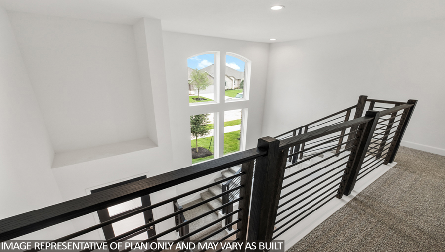 Upstairs loft with carpet flooring, a balcony overlooking the family room downstairs, and an entrance to the attic.