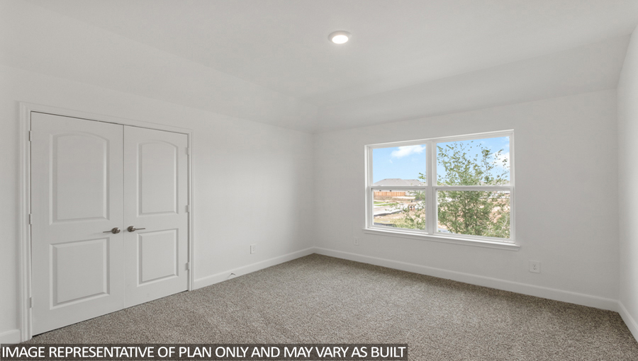 Secondary bedroom with carpet flooring and bright windows.