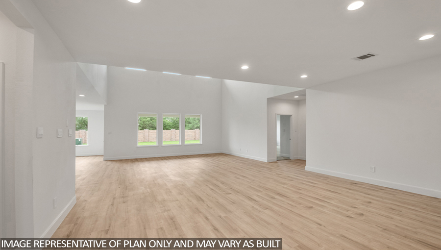 Open concept living and dining area with vinyl flooring and bright windows.