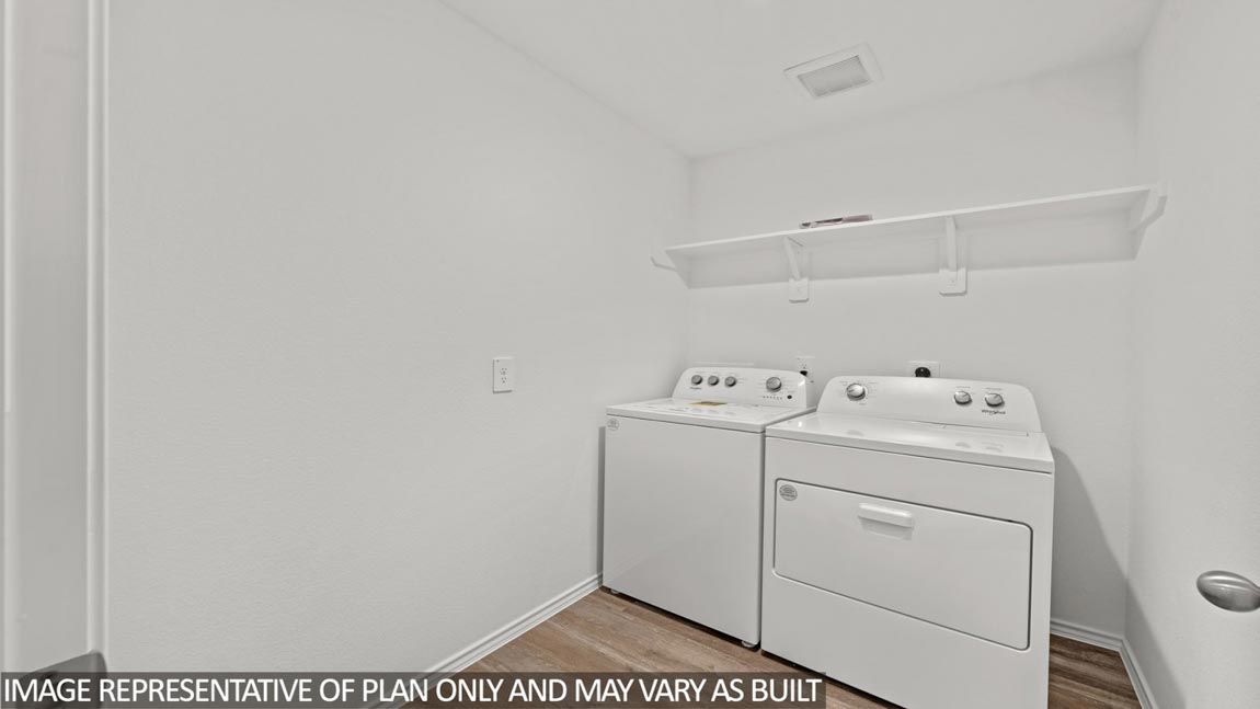 Utility room with vinyl flooring and overhead storage space.