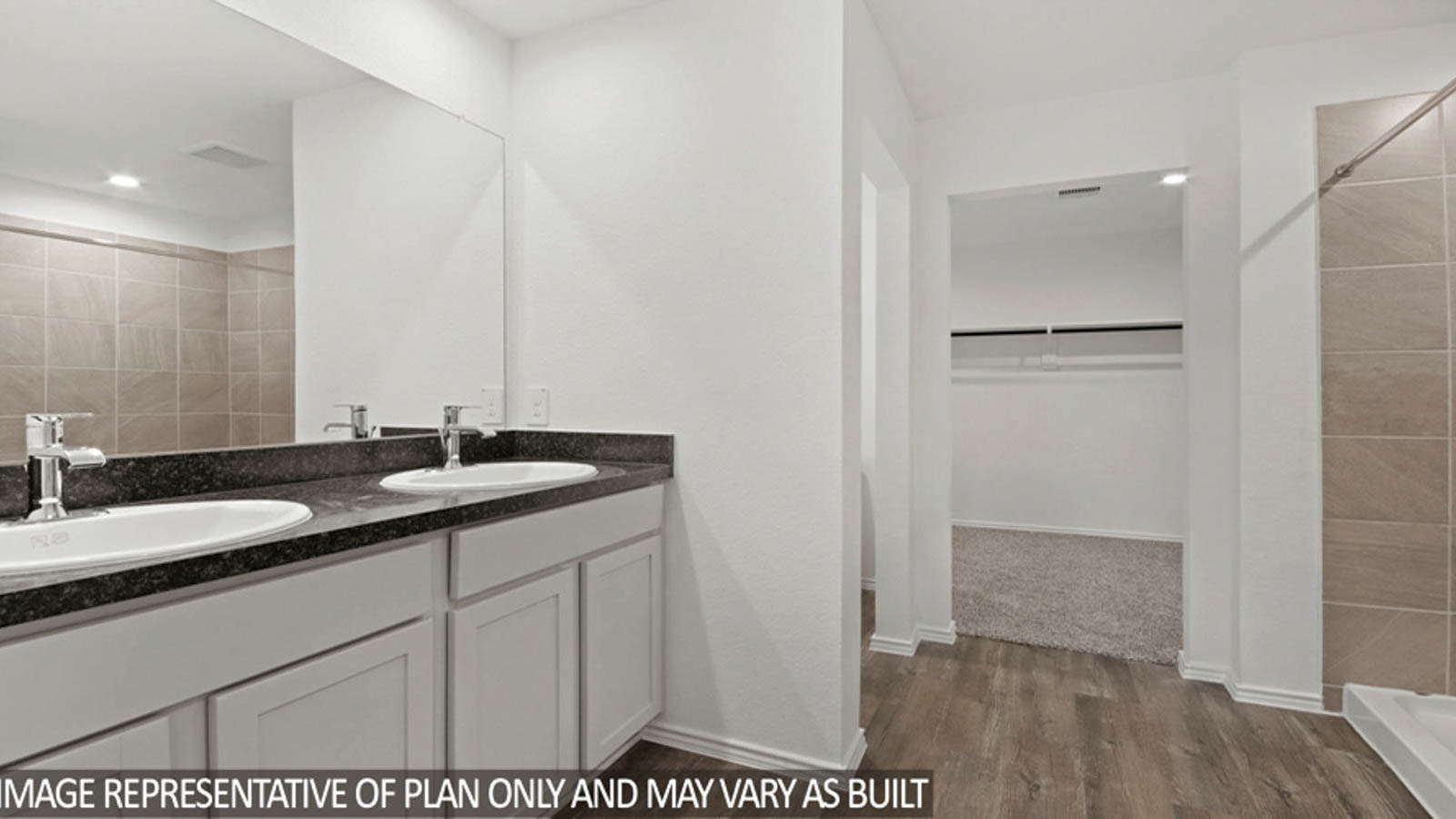 Primary bathroom with a double sink, a walk-in closet, and a separate toilet room.